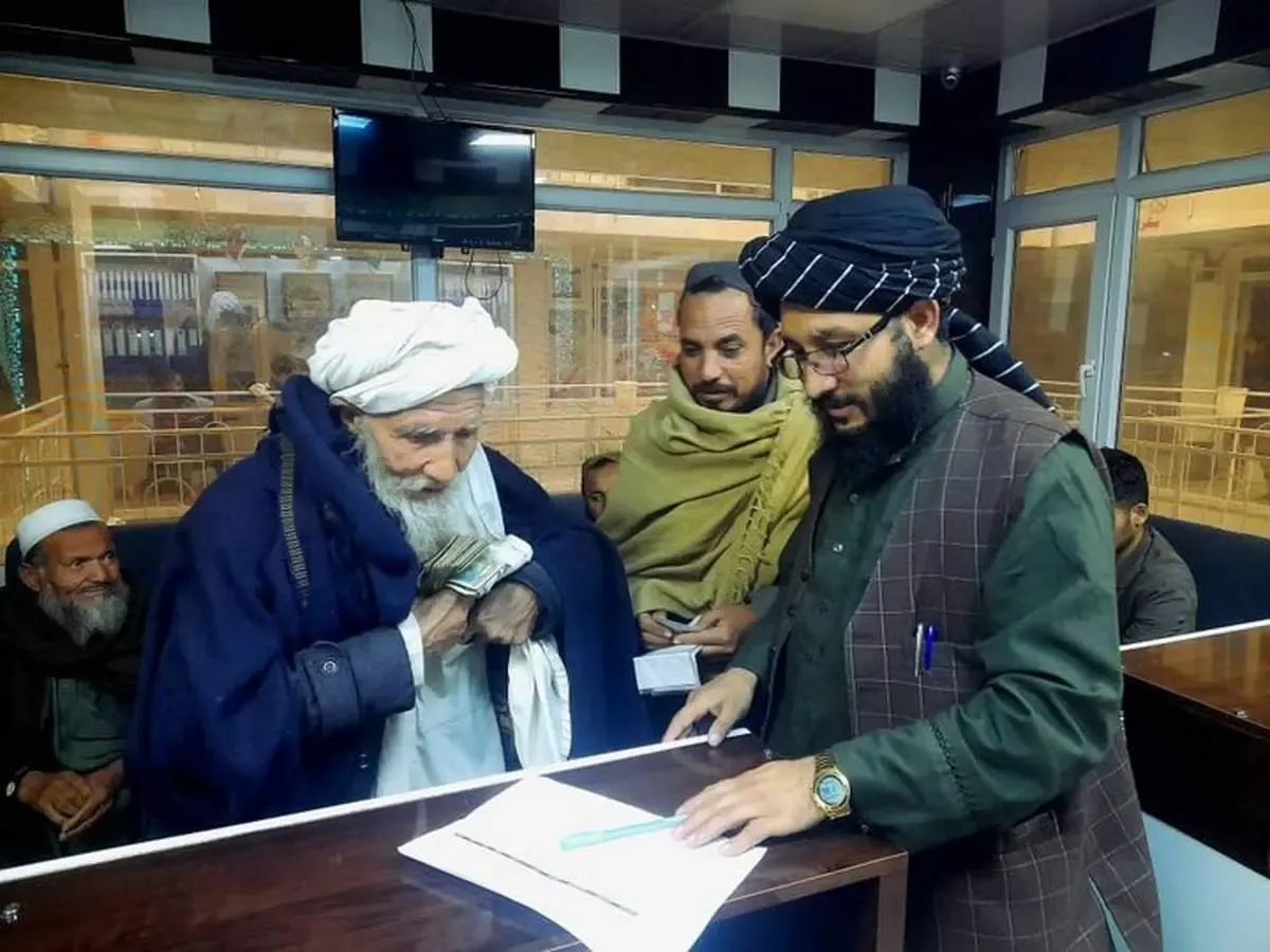 تصاویری از توزیع پول و غذا بین مهاجران افغان توسط طالبان