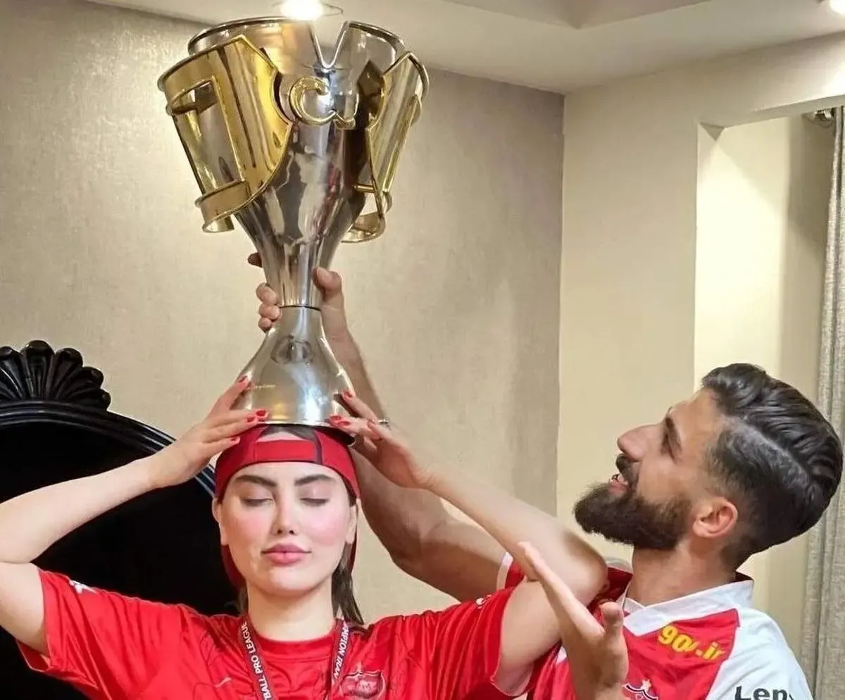 ژست های عجیب همسر فرشاد فرجی با جام قهرمانی پرسپولیس در منزل! / تصاویر